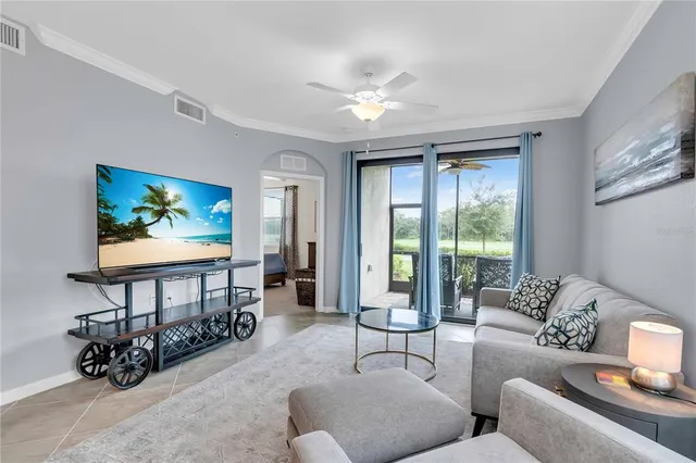 a living room with furniture a window and a flat screen tv