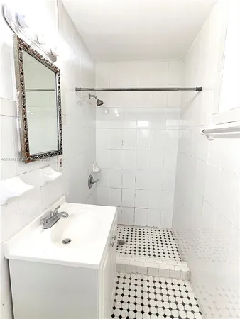 a bathroom with a sink a shower a mirror and a shower