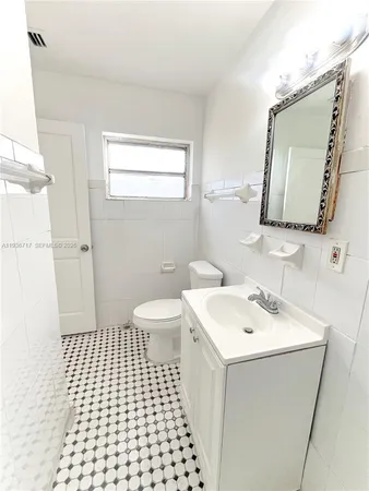 a bathroom with a sink a toilet and mirror