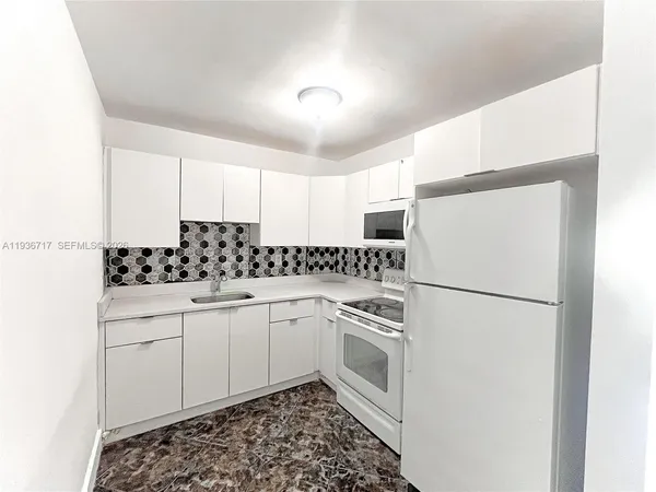 a kitchen with a refrigerator sink and cabinets