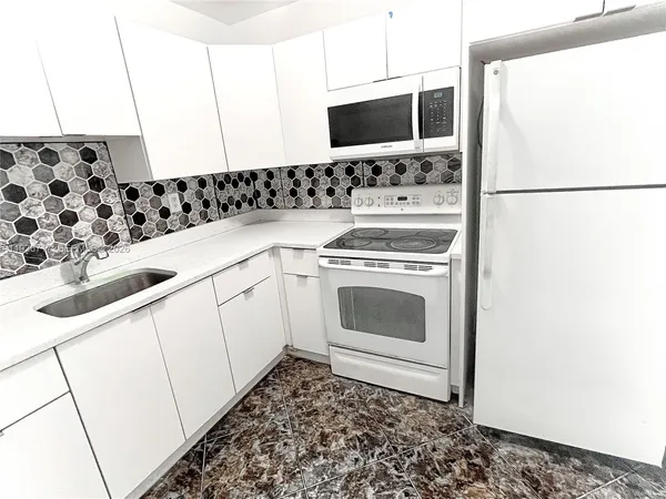 a kitchen with a sink stove and microwave