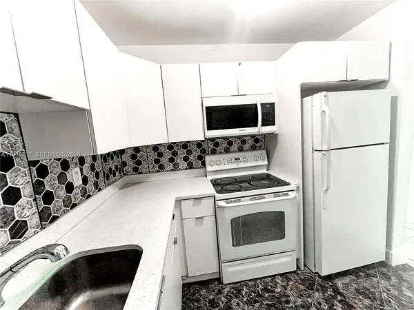 a kitchen with a refrigerator stove and microwave