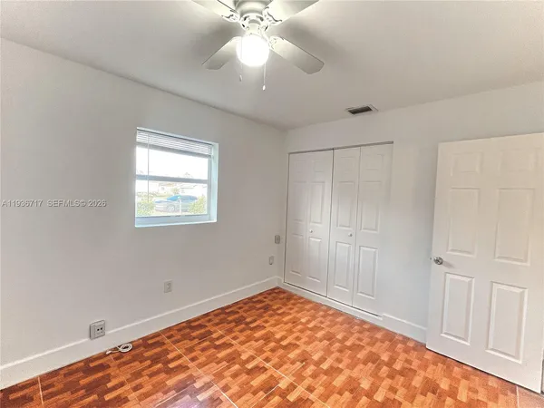 a view of a room with a ceiling fan and a window
