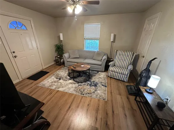 a living room with furniture and a wooden floor