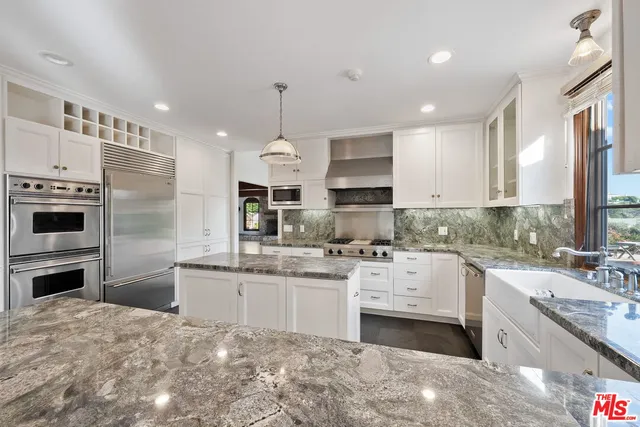 a kitchen with stainless steel appliances granite countertop a sink a stove and a refrigerator