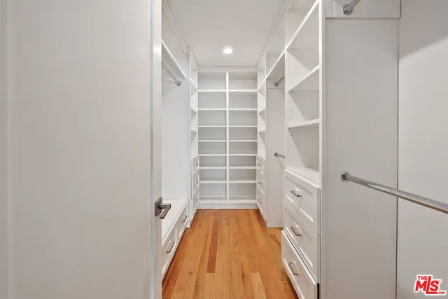 a view of walk in closet with empty racks