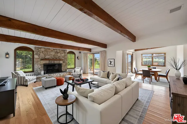 a living room with furniture fireplace and a large window