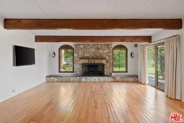 a view of empty room with wooden floor and fireplace