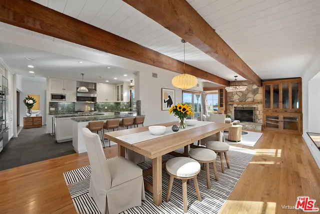 a dining room with stainless steel appliances kitchen island granite countertop a dining table chairs and view of kitchen