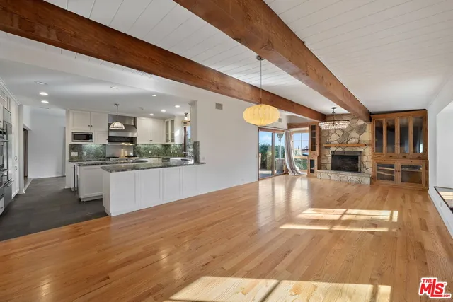 a view of kitchen with kitchen island a sink dishwasher stove and white cabinets with wooden floor