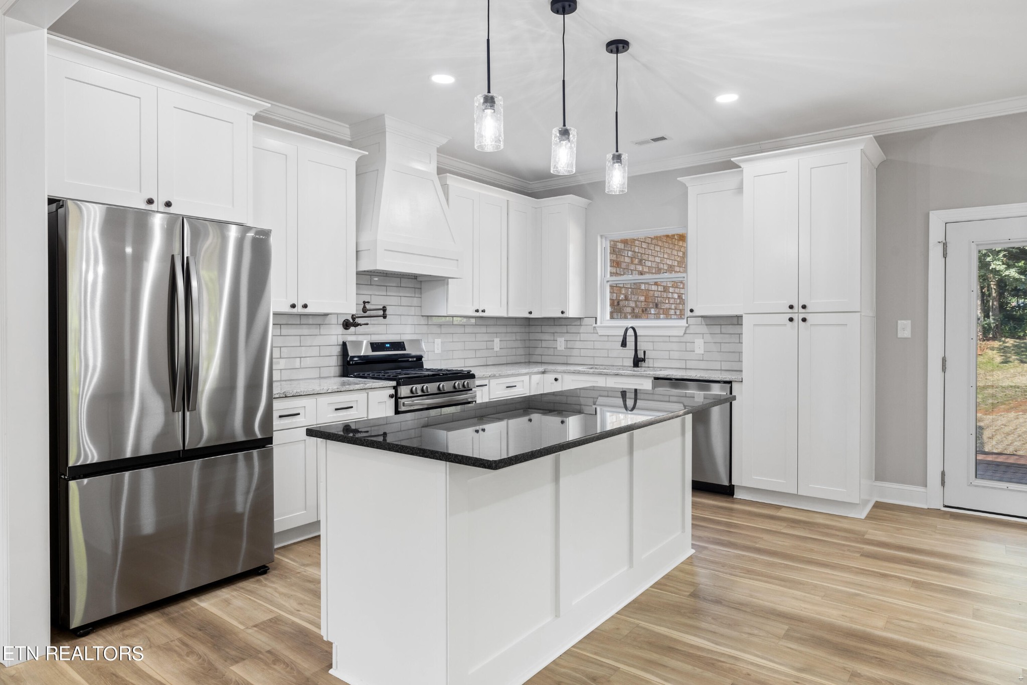 2333 Mountain View Road Lenoir City, TN 37771 - Photo 11 of 54 a kitchen with stainless steel appliances granite countertop a refrigerator a sink dishwasher a stove and white cabinets with wooden floor