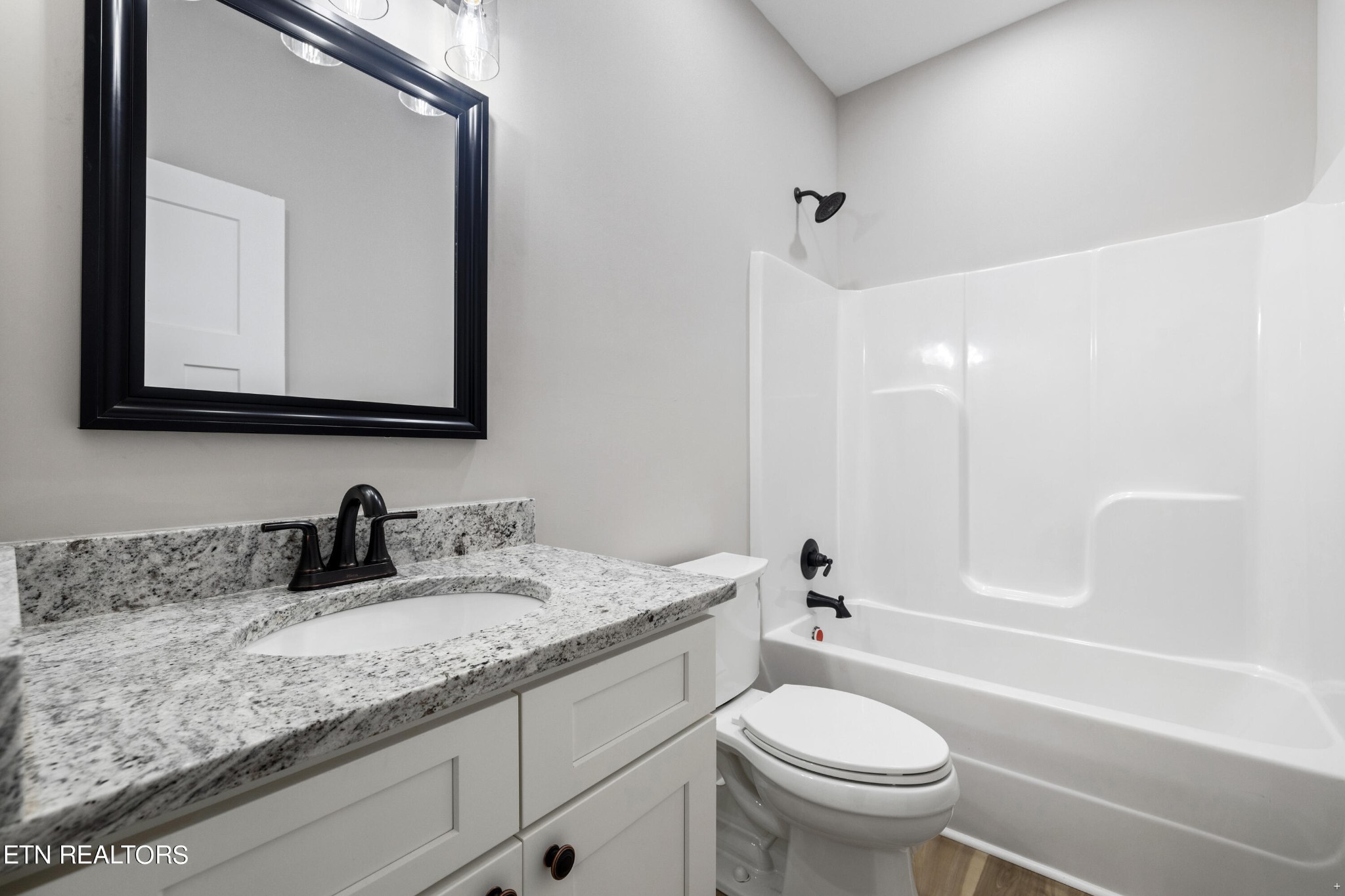 2333 Mountain View Road Lenoir City, TN 37771 - Photo 32 of 54 a bathroom with a granite countertop toilet a sink and a mirror