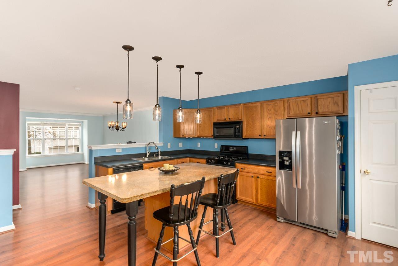 8716 Winding River Way Raleigh, NC 27616 - Photo 3 of 30 a kitchen with stainless steel appliances a dining table chairs and wooden floor