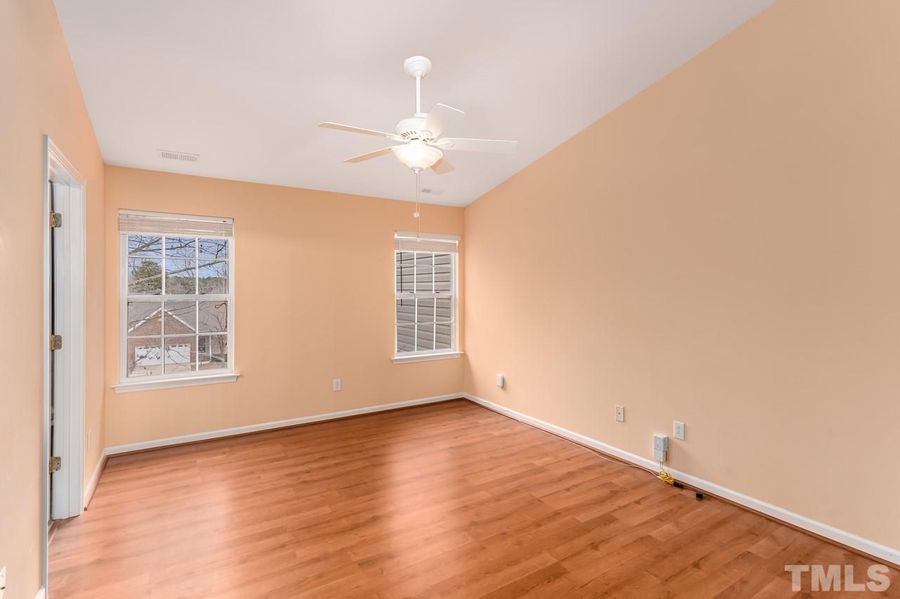 8716 Winding River Way Raleigh, NC 27616 - Photo 22 of 30 an empty room with wooden floor fan and windows