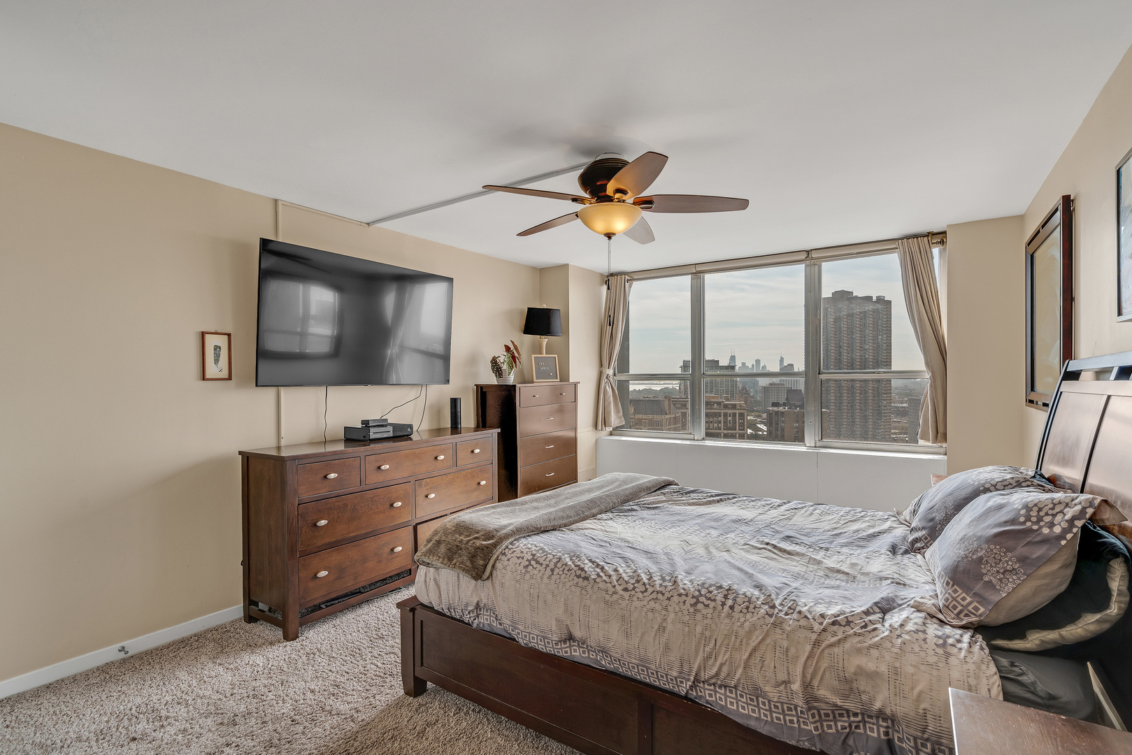 655 West Irving Park Road, Unit 2401 Chicago, IL 60613 - Photo 17 of 32 a bedroom with a bed and a flat screen tv