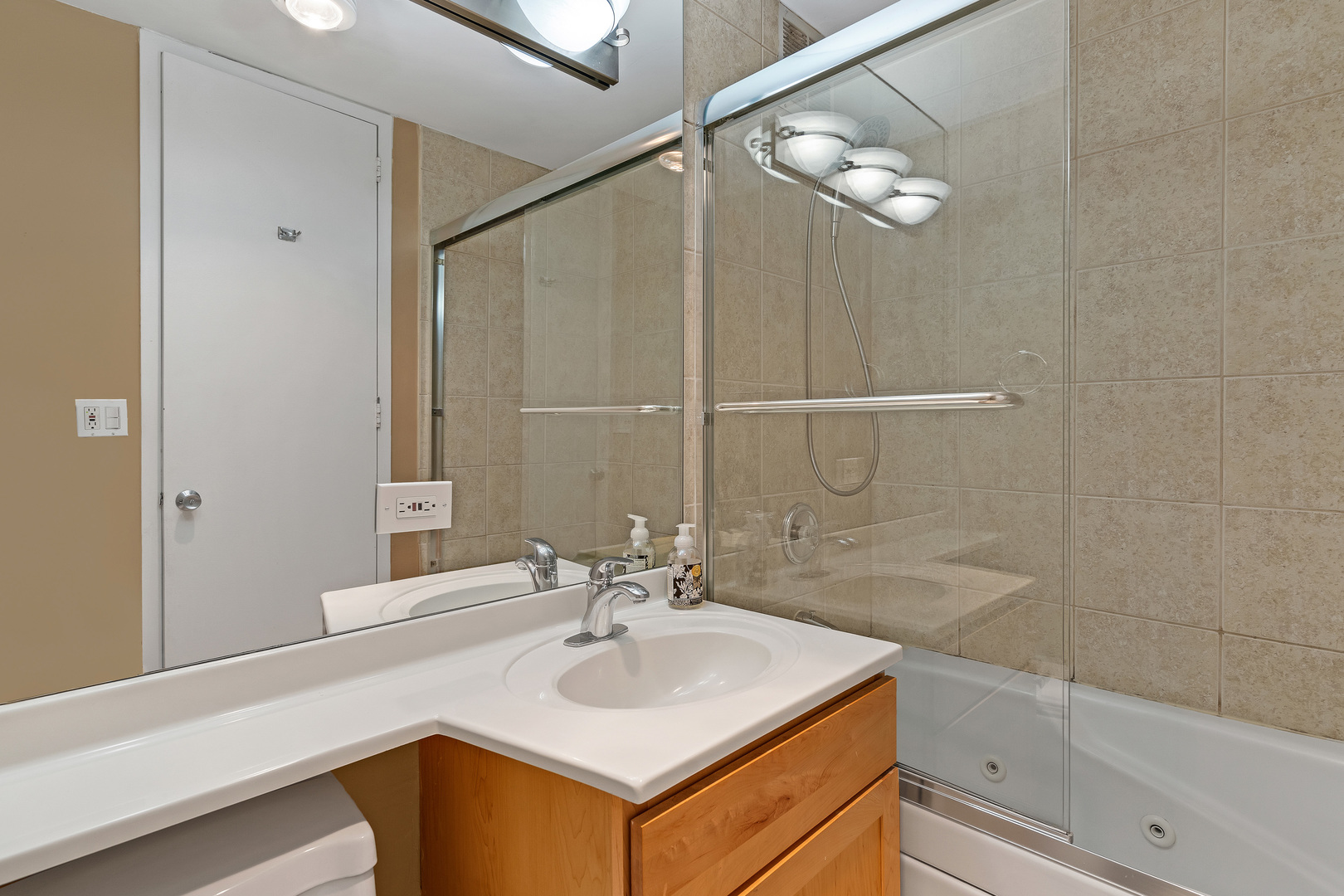 655 West Irving Park Road, Unit 2401 Chicago, IL 60613 - Photo 19 of 32 a bathroom with a sink a mirror and a shower