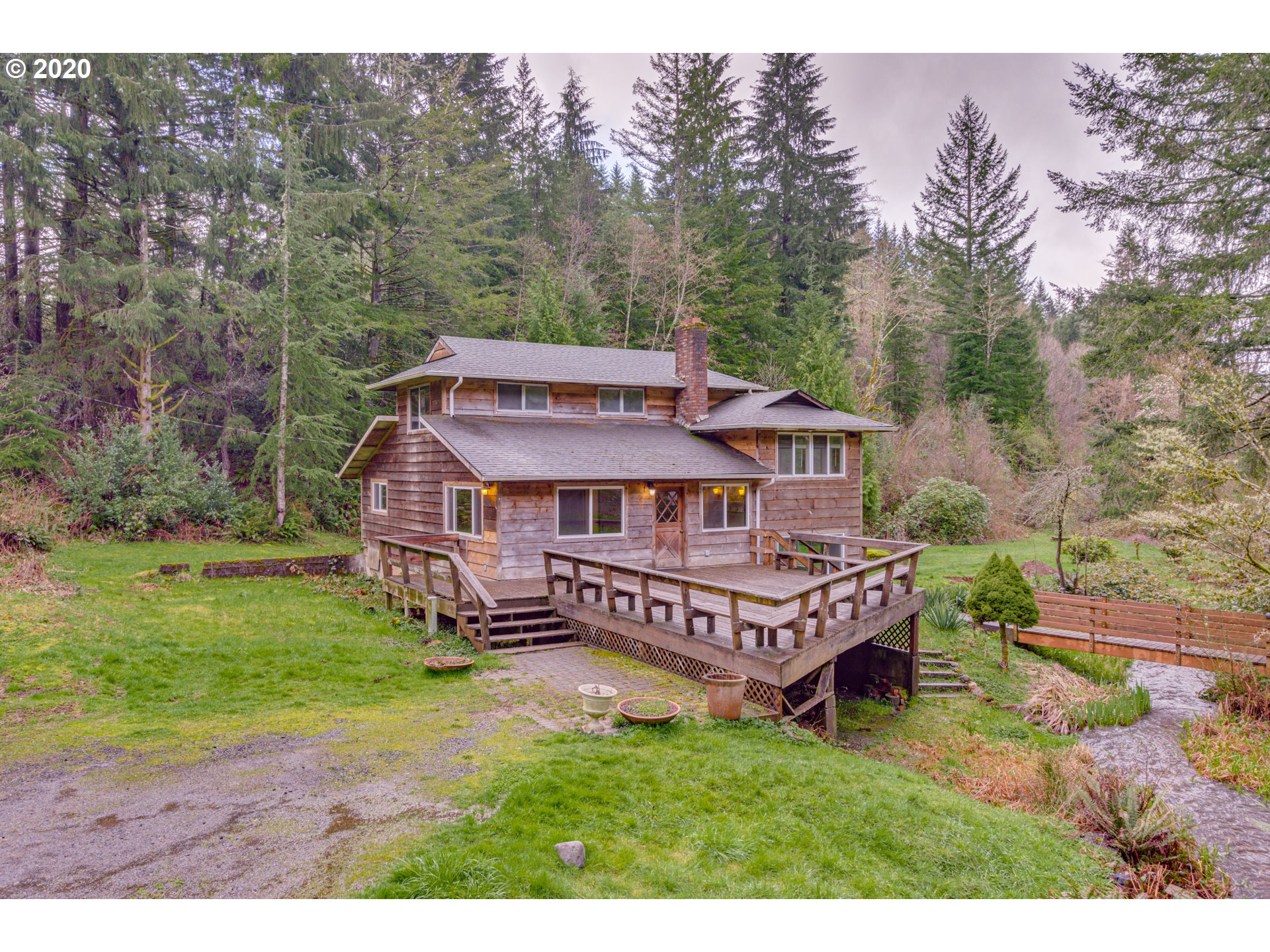 a view of a house with a big yard and large trees