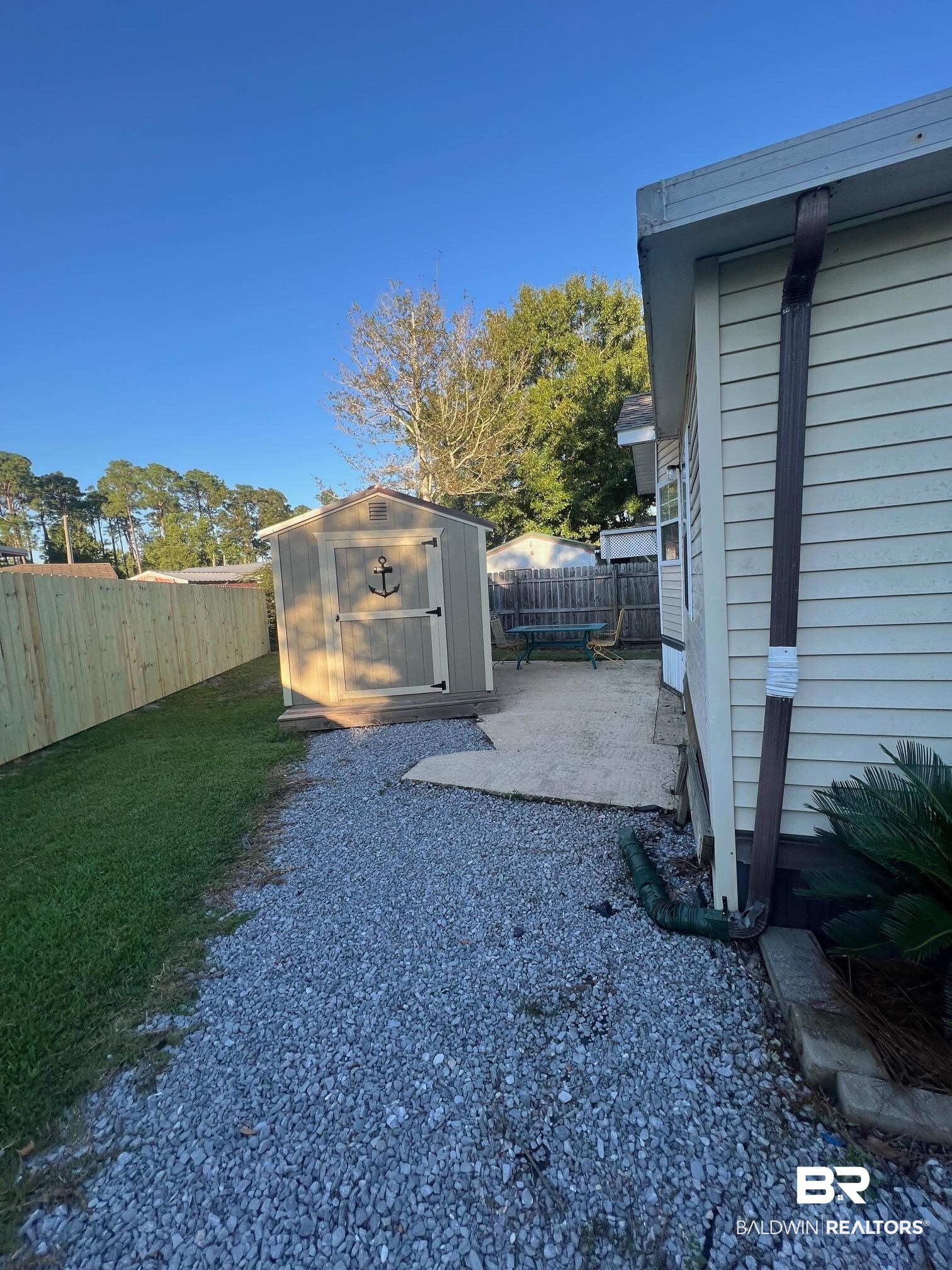 698 Escambia Loop Lillian, AL 36549 - Photo 13 of 16 View of yard with a storage unit and a patio area