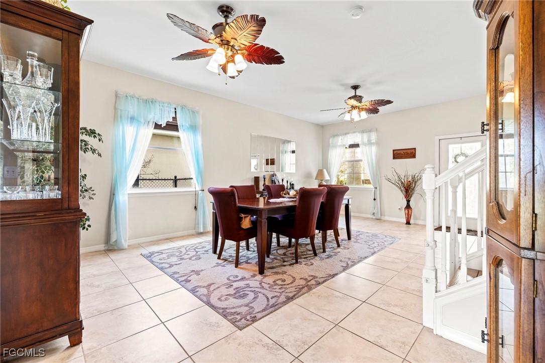8657 Sumner Avenue Fort Myers, FL 33908 - Photo 5 of 29 a view of a dining room and livingroom with furniture wooden floor a rug a flat screen tv a rug a fireplace and a chandelier