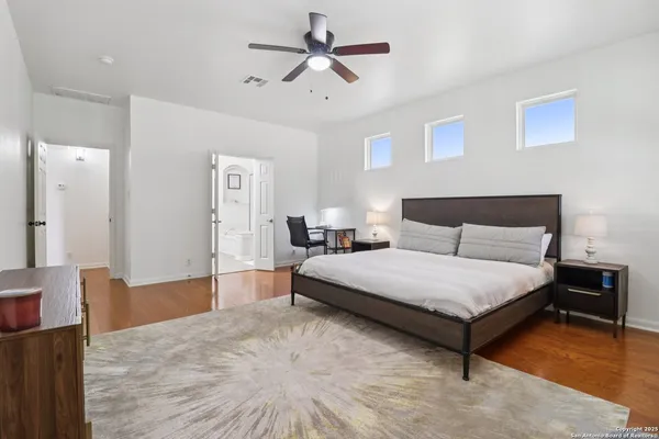 a spacious bedroom with a bed and a chandelier