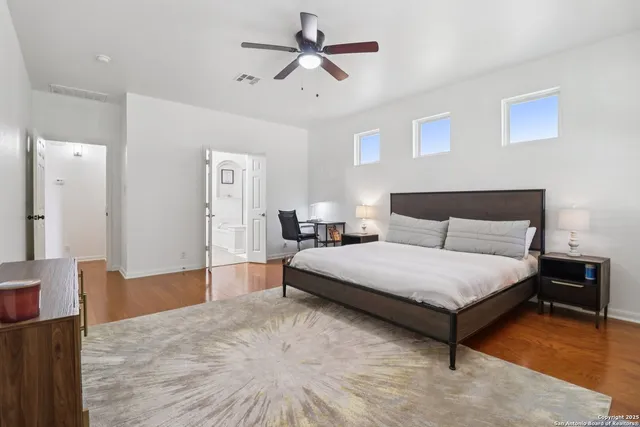 a spacious bedroom with a bed and a chandelier
