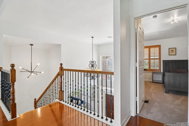 a view of staircase with lots of frames on wall and a window