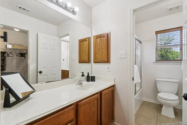 a bathroom with a sink a toilet a shower and a mirror