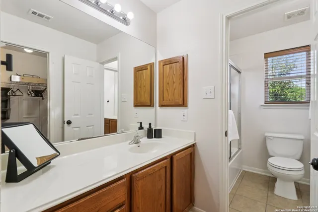 a bathroom with a sink a toilet a shower and a mirror