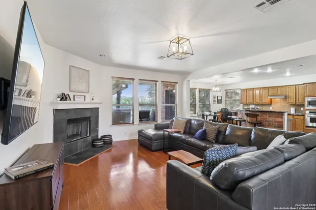 a living room with furniture a fireplace and a flat screen tv