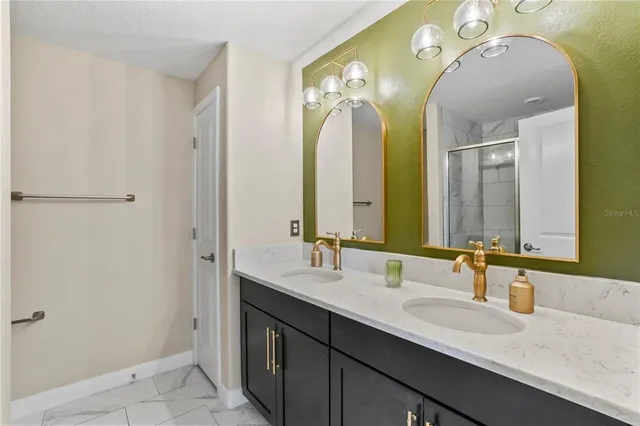 a bathroom with a granite countertop double vanity sink and a mirror
