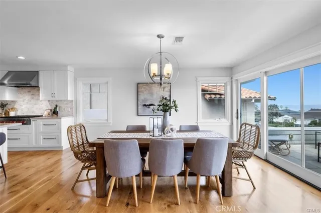 a kitchen with stainless steel appliances granite countertop a sink a stove a kitchen island with chairs and white cabinets