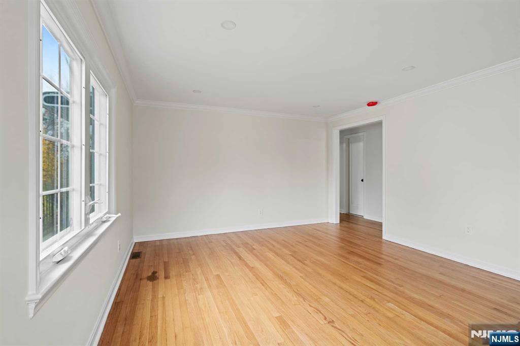 238 Springfield Avenue, Unit 1 Rutherford, NJ 07070 - Photo 4 of 33 a view of an empty room with wooden floor and a window