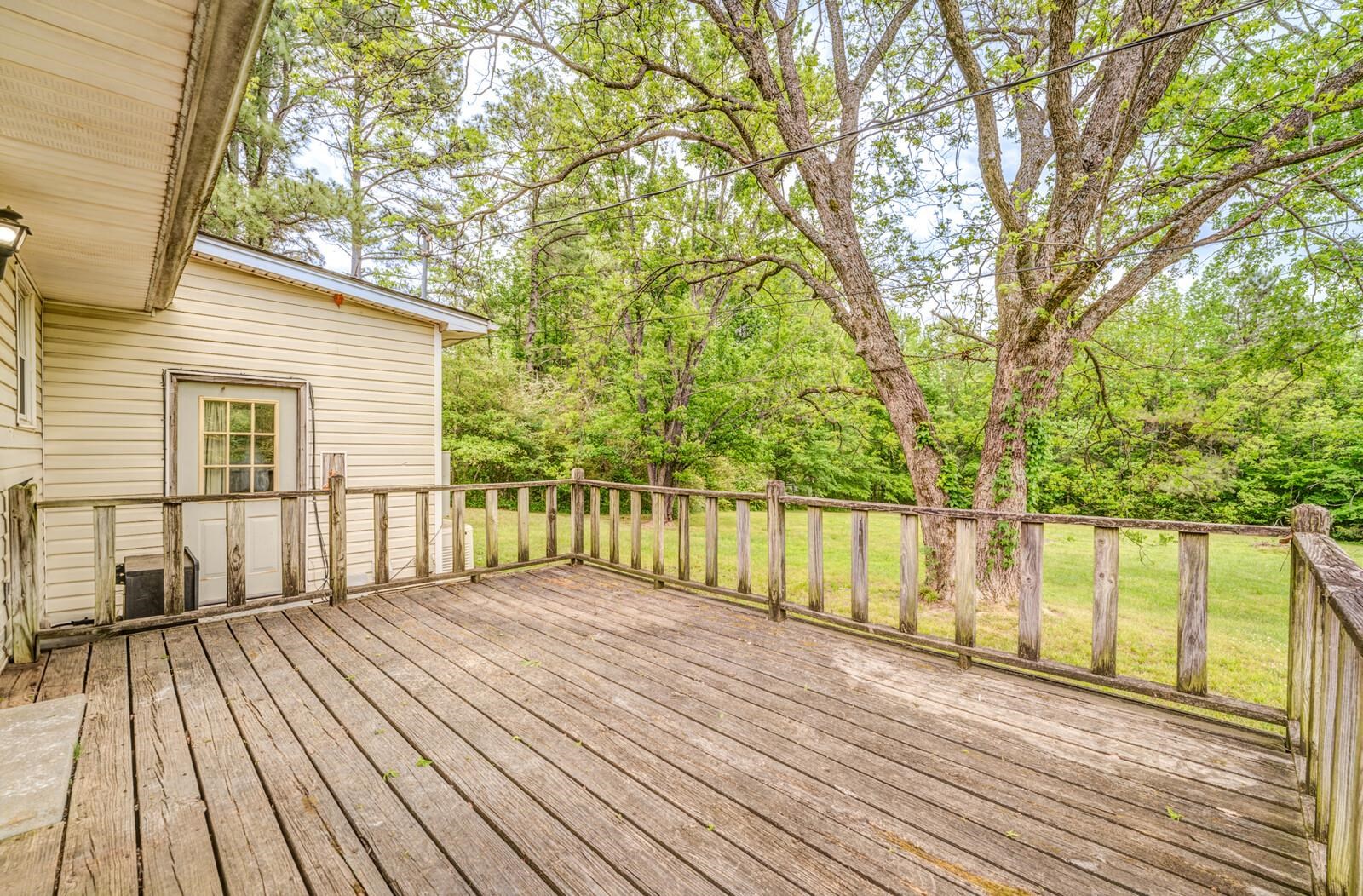6125 Warren Road Oakland, TN 38060 - Photo 35 of 40 Spacious outdoor deck with natural wood railing overlooking a grassy expanse