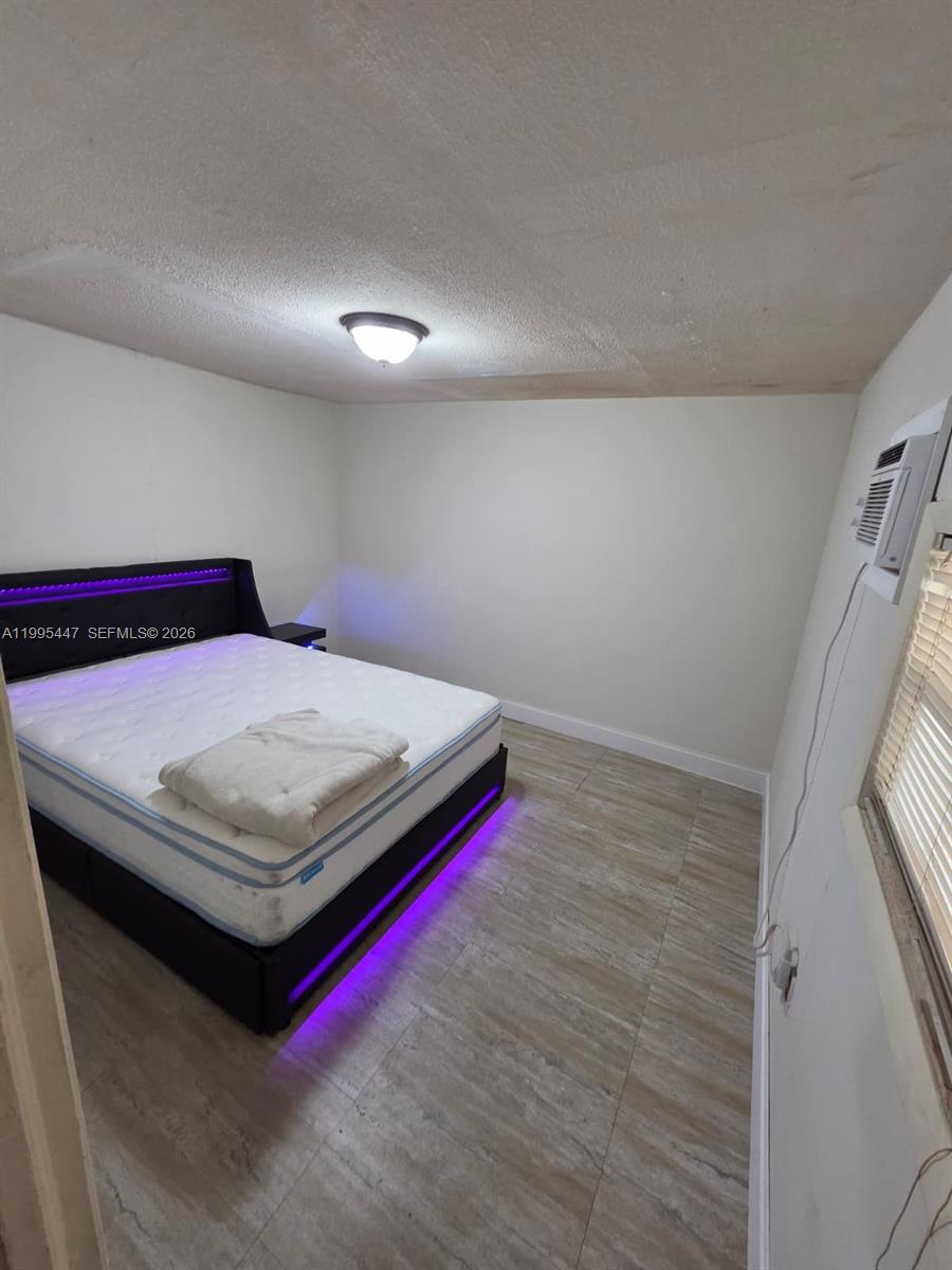 1420 Southwest 129th Court, Unit 1 Miami, FL 33184 - Photo 2 of 11 a bedroom with a bed and a large window