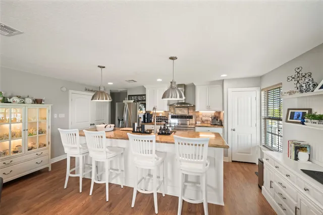 a view of a dining room and livingroom with furniture wooden floor kitchen view and dining table