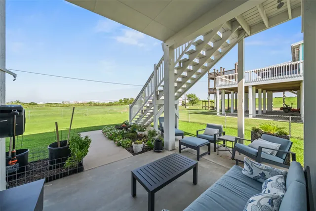 a view of a swimming pool with a couches and chairs in patio