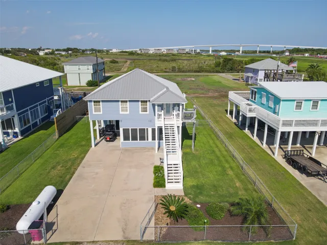 an aerial view of residential houses with outdoor space and lakeside