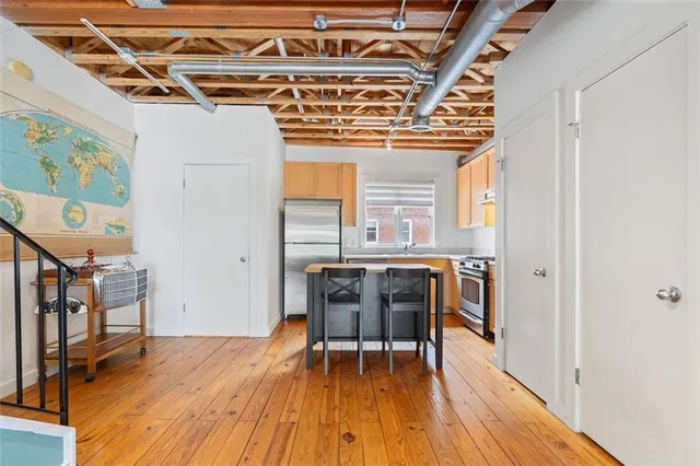 a kitchen with stainless steel appliances granite countertop a table chairs and a refrigerator