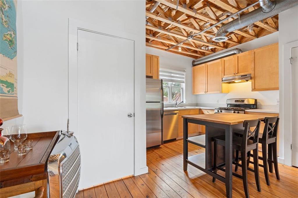 322 Peters Street Southwest, Unit 2 Atlanta, GA 30313 - Photo 16 of 58 a kitchen with stainless steel appliances granite countertop a table chairs and a refrigerator