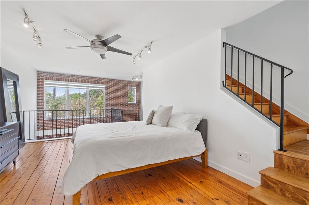322 Peters Street Southwest, Unit 2 Atlanta, GA 30313 - Photo 27 of 58 a bedroom with a bed and a large window with wooden floor