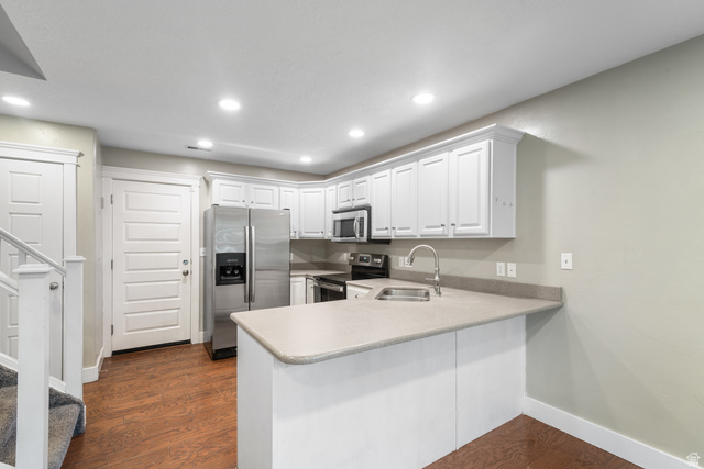 273 West 1010th Street South Logan, UT 84321 - Photo 8 of 19 Kitchen with stainless steel appliances, light countertops, a peninsula, white cabinetry, and dark wood-type flooring