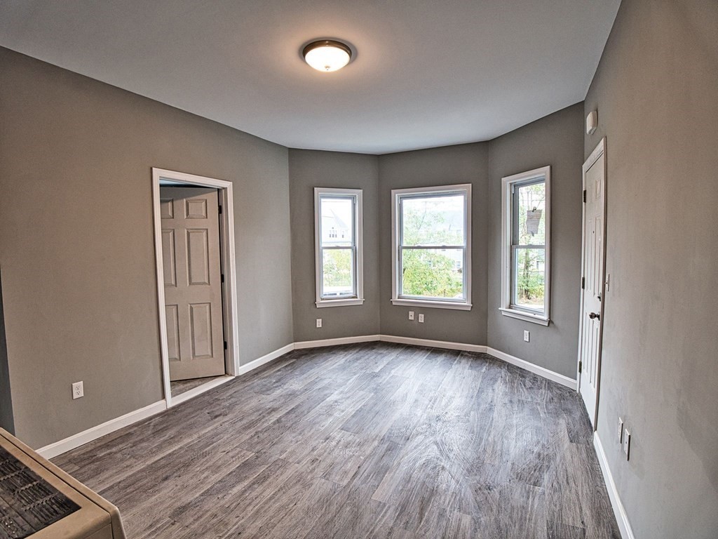 62 Bay Street Fall River, MA 02721 - Photo 5 of 21 an empty room with wooden floor and windows