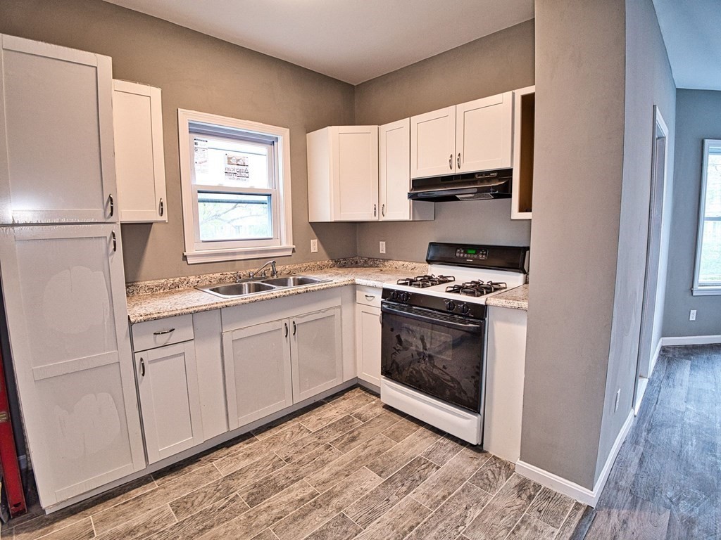 62 Bay Street Fall River, MA 02721 - Photo 7 of 21 a kitchen with granite countertop white cabinets and white appliances