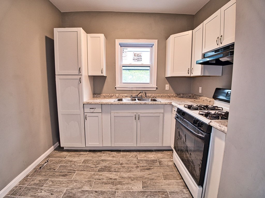 62 Bay Street Fall River, MA 02721 - Photo 8 of 21 a kitchen with stainless steel appliances a stove a sink and a refrigerator
