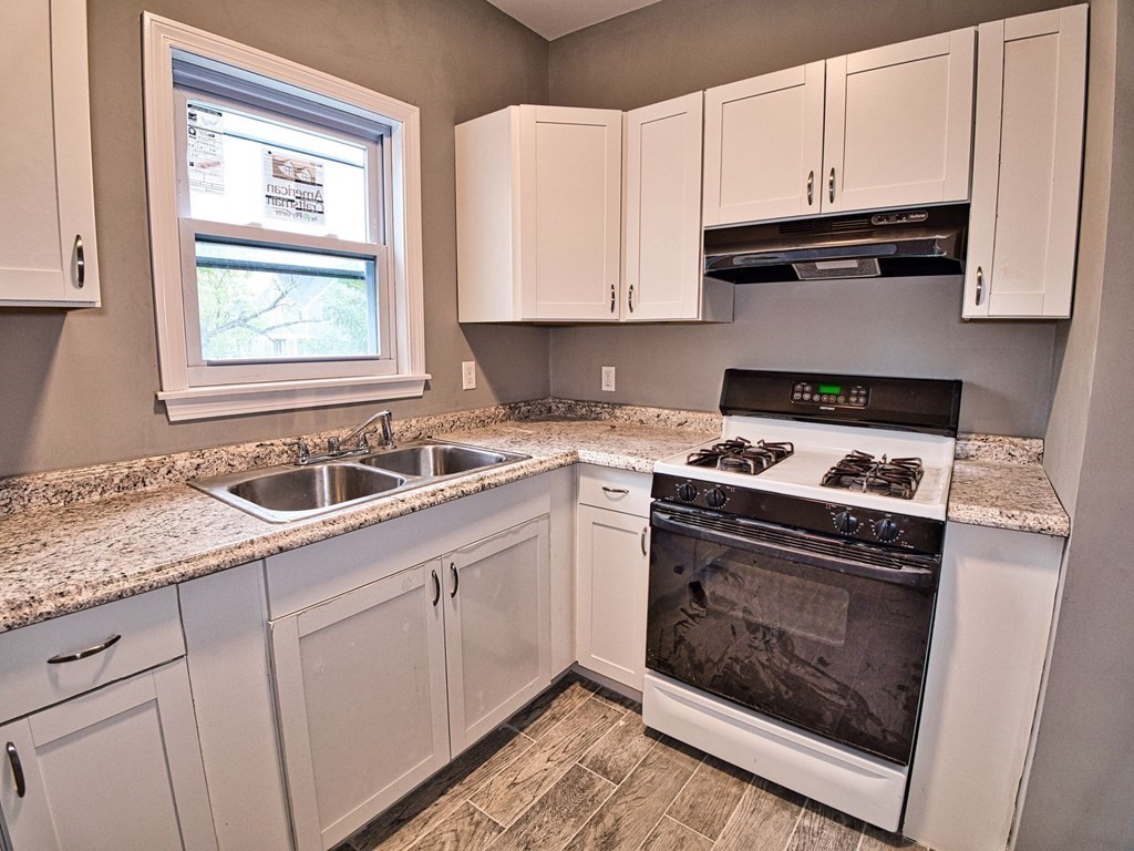 62 Bay Street Fall River, MA 02721 - Photo 9 of 21 a kitchen with granite countertop white cabinets and appliances