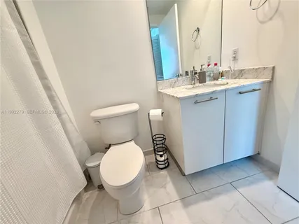 a bedroom with a bed a couch and potted plant