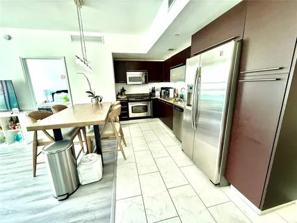 a kitchen with stainless steel appliances granite countertop a refrigerator a stove and a sink