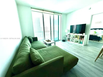 a bedroom with a bed a couch and a window