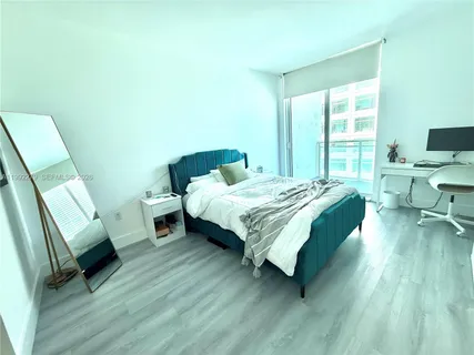 a bedroom with a bed a couch and a window