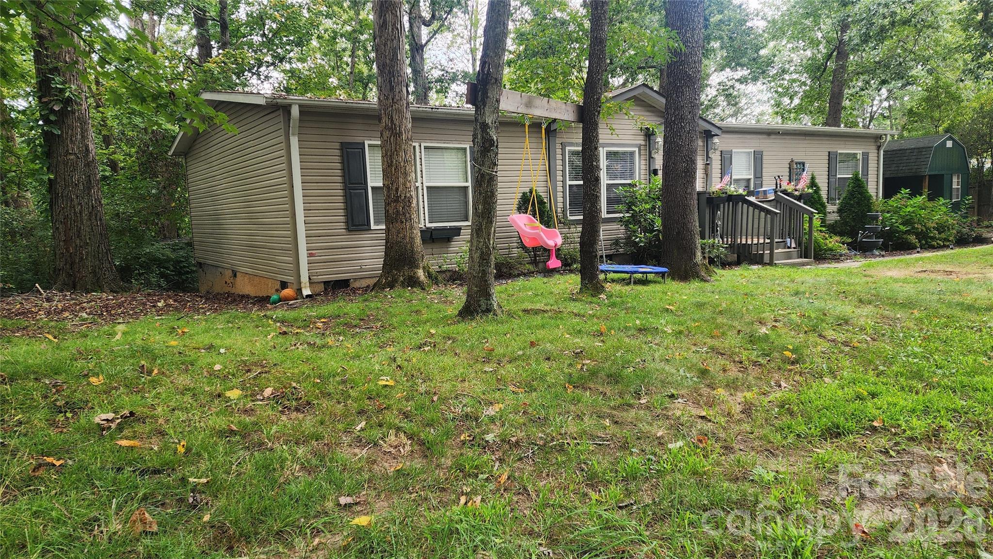 67 Indian Trail Road Candler, NC 28715 - Photo 2 of 31 a view of a house with backyard and a tree